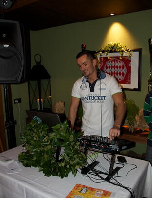 DJ mit Hut an den Decks, Retro-Deko und Vinyls.